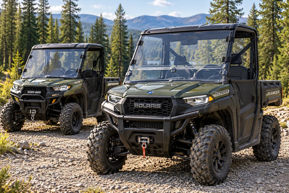 Polaris Ranger with a clear two-piece combo windshield in front of a Can-Am Defender with a full windshield.