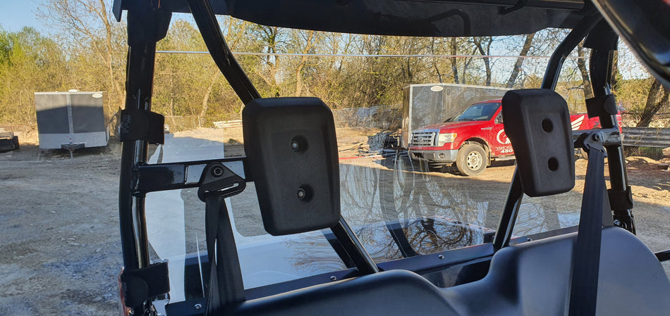 Inside view of a Honda Pioneer 520 rear windshield, showing the mounting plates behind the seats.